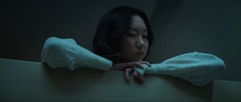 Movie still from “The Boogeyman” (2023), directed by Rob Savage – A young woman is holding her arms around her back; Close Up shot, High angle