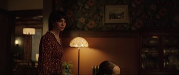 Movie still from “The Boogeyman” (2023), directed by Rob Savage – A woman standing next to a lamp in a room; Medium shot, Over the shoulder angle