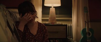 Movie still from “The Boogeyman” (2023), directed by Rob Savage – A woman sitting in front of a lamp in a room; Close Up shot, Over the shoulder angle