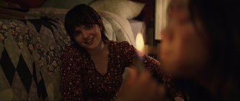 Movie still from “The Boogeyman” (2023), directed by Rob Savage – A woman sitting on the floor with a lit candle in front of her face; Close Up shot, Over the shoulder angle