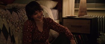 Movie still from “The Boogeyman” (2023), directed by Rob Savage – A woman sitting on a bed smiling at the camera; Medium shot, Over the shoulder angle