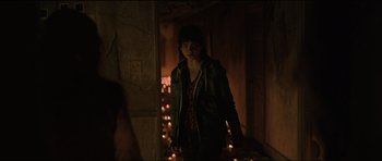 Movie still from “The Boogeyman” (2023), directed by Rob Savage – A woman standing in a hallway with candles; Medium shot, Over the shoulder angle