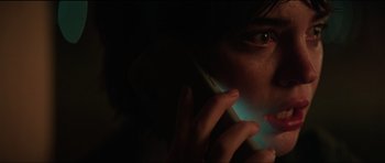 Movie still from “The Boogeyman” (2023), directed by Rob Savage – A person is talking on a cell phone in the dark; Close Up shot, Low angle