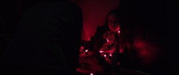 Movie still from “The Boogeyman” (2023), directed by Rob Savage – A little girl sitting on the ground with a bunch of lights; Medium shot, Over the shoulder angle