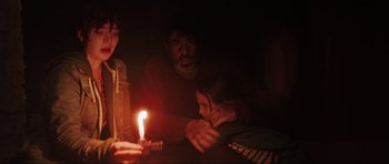 Movie still from “The Boogeyman” (2023), directed by Rob Savage – A man and a child sitting in front of a lit candle; Medium shot, Over the shoulder angle