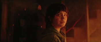 Movie still from “The Boogeyman” (2023), directed by Rob Savage – A woman is looking at the camera while standing in a dimly - lit room; Close Up shot, Over the shoulder angle