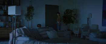 Movie still from “The Boogeyman” (2023), directed by Rob Savage – A person standing in a living room in front of a door; Wide shot, Over the shoulder angle