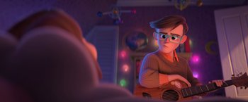 Movie still from “The Boss Baby 2: Family Business” (2021), directed by Tom McGrath – A man with glasses is holding a guitar; Medium shot, Over the shoulder angle
