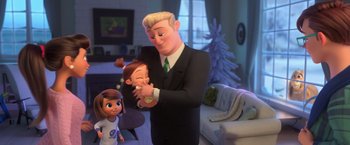Movie still from “The Boss Baby 2: Family Business” (2021), directed by Tom McGrath – A man in a suit holding a baby in his arms in a living room; Medium shot, Over the shoulder angle