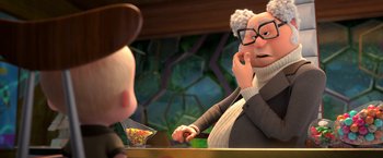 Movie still from “The Boss Baby 2: Family Business” (2021), directed by Tom McGrath – An old man is sitting at a table talking on the phone; Medium shot, Over the shoulder angle