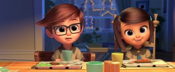 Movie still from “The Boss Baby 2: Family Business” (2021), directed by Tom McGrath – A boy with glasses sitting at a table with a cup; Medium shot, Over the shoulder angle