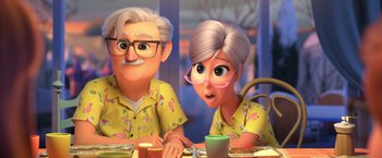 Movie still from “The Boss Baby 2: Family Business” (2021), directed by Tom McGrath – An old man and a young woman sitting at a dinner table; Medium shot, Over the shoulder angle