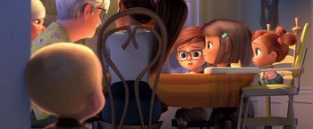 Movie still from “The Boss Baby 2: Family Business” (2021), directed by Tom McGrath – A woman sitting at a table with a cup of coffee; Medium shot, Over the shoulder angle