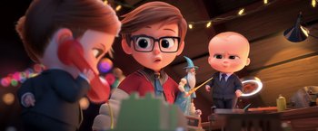 Movie still from “The Boss Baby 2: Family Business” (2021), directed by Tom McGrath – A group of people that are standing around a table; Medium shot, Over the shoulder angle