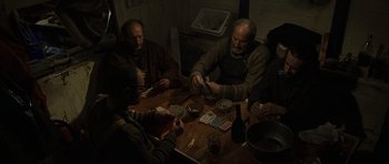 Movie still from “The Bourne Identity” (2002), directed by Doug Liman – A group of men sitting at a table playing cards; Medium shot, High angle