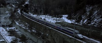 Movie still from “The Bourne Identity” (2002), directed by Doug Liman – A train traveling down tracks next to snow covered ground; Extreme Wide shot, High angle
