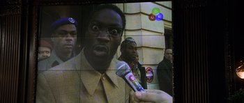 Movie still from “The Bourne Identity” (2002), directed by Doug Liman – A man is being interviewed on a television screen; Close Up shot, Low angle
