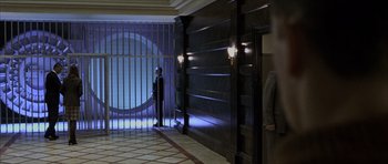 Movie still from “The Bourne Identity” (2002), directed by Doug Liman – A person standing in a room with a door open; Wide shot, Low angle
