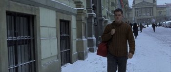 Movie still from “The Bourne Identity” (2002), directed by Doug Liman – A man walking down a street holding a bag; Wide shot, Low angle