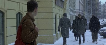 Movie still from “The Bourne Identity” (2002), directed by Doug Liman – Three people walking down a snowy sidewalk in the snow; Medium shot, Over the shoulder angle
