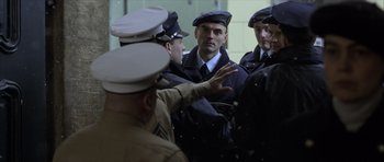 Movie still from “The Bourne Identity” (2002), directed by Doug Liman – A group of men in uniform talking to each other; Medium shot, Over the shoulder angle