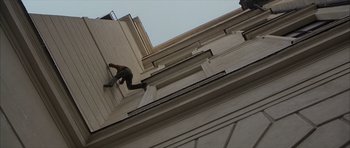 Movie still from “The Bourne Identity” (2002), directed by Doug Liman – A man climbing up the side of a tall building; Wide shot, Overhead angle