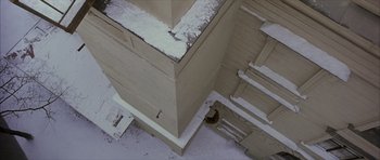 Movie still from “The Bourne Identity” (2002), directed by Doug Liman – An aerial view of a building with snow on the roof; Extreme Wide shot, Overhead angle