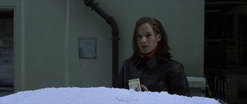 Movie still from “The Bourne Identity” (2002), directed by Doug Liman – A woman is holding a piece of paper in her hand; Medium shot, Low angle