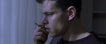 Movie still from “The Bourne Identity” (2002), directed by Doug Liman – A young man is holding a pen in his mouth; Close Up shot, Low angle