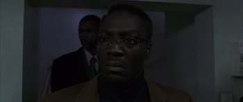 Movie still from “The Bourne Identity” (2002), directed by Doug Liman – A person wearing a suit and glasses; Close Up shot, Low angle