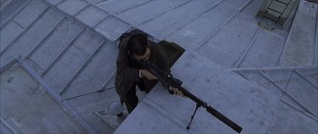 Movie still from “The Bourne Identity” (2002), directed by Doug Liman – A man is holding a rifle on the stairs; Wide shot, High angle