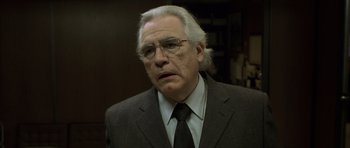 Movie still from “The Bourne Identity” (2002), directed by Doug Liman – An older man wearing a suit and tie; Close Up shot, Low angle