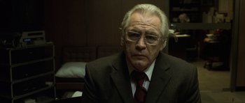 Movie still from “The Bourne Identity” (2002), directed by Doug Liman – An older man wearing a suit and tie; Close Up shot, Low angle