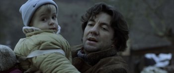 Movie still from “The Bourne Identity” (2002), directed by Doug Liman – A man holding a child in his arms; Close Up shot, Low angle
