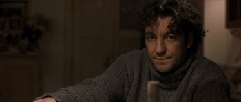 Movie still from “The Bourne Identity” (2002), directed by Doug Liman – A person wearing a gray sweater; Close Up shot, Over the shoulder angle