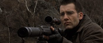 Movie still from “The Bourne Identity” (2002), directed by Doug Liman – A man with glasses is holding a rifle; Close Up shot, Low angle
