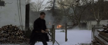 Movie still from “The Bourne Identity” (2002), directed by Doug Liman – A man in a black coat is holding a sword; Wide shot, High angle