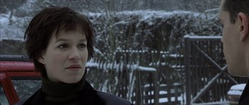 Movie still from “The Bourne Identity” (2002), directed by Doug Liman – A person wearing a black jacket near a wooden fence; Close Up shot, Over the shoulder angle