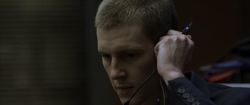 Movie still from “The Bourne Identity” (2002), directed by Doug Liman – A person with a headset on; Close Up shot, Over the shoulder angle