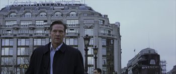 Movie still from “The Bourne Identity” (2002), directed by Doug Liman – A man standing in front of a tall building; Medium shot, Low angle
