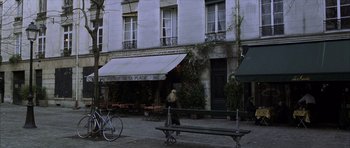 Movie still from “The Bourne Identity” (2002), directed by Doug Liman – A bicycle parked on the side of a road near a building; Wide shot, High angle