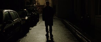 Movie still from “The Bourne Identity” (2002), directed by Doug Liman – A man standing in the middle of a street at night; Wide shot, Low angle