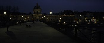 Movie still from “The Bourne Identity” (2002), directed by Doug Liman – A pier with a building in the background lit up at night; Extreme Wide shot, High angle
