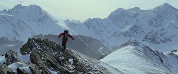 Movie still from “The Bourne Legacy” (2012), directed by Tony Gilroy – A man is climbing up a hill in the snow; Extreme Wide shot, Low angle