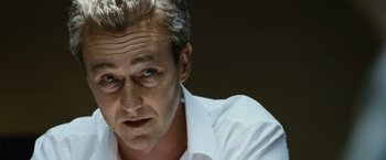 Movie still from “The Bourne Legacy” (2012), directed by Tony Gilroy – A person wearing a white dress shirt; Close Up shot, Low angle