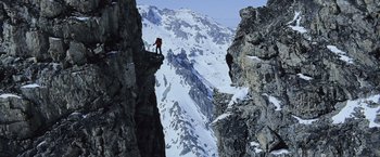 Movie still from “The Bourne Legacy” (2012), directed by Tony Gilroy – A man standing on a rock on top of a mountain; Extreme Wide shot, Low angle