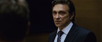 Movie still from “The Bourne Legacy” (2012), directed by Tony Gilroy – A person wearing a suit and tie; Close Up shot, Over the shoulder angle