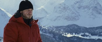 Movie still from “The Bourne Legacy” (2012), directed by Tony Gilroy – A man standing on top of a snow covered slope; Medium shot, Low angle