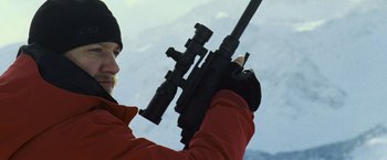 Movie still from “The Bourne Legacy” (2012), directed by Tony Gilroy – A man holding a rifle in his hands; Close Up shot, Over the shoulder angle