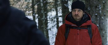 Movie still from “The Bourne Legacy” (2012), directed by Tony Gilroy – A man in a red jacket standing next to a tree; Medium shot, Over the shoulder angle